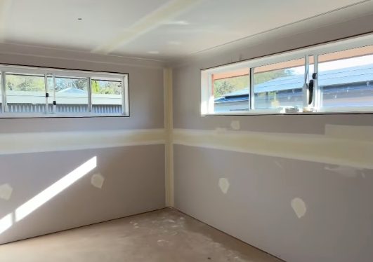 A finished room in a new granny flat, sheeted and set, with the joints sanded flush and ready for the painter.