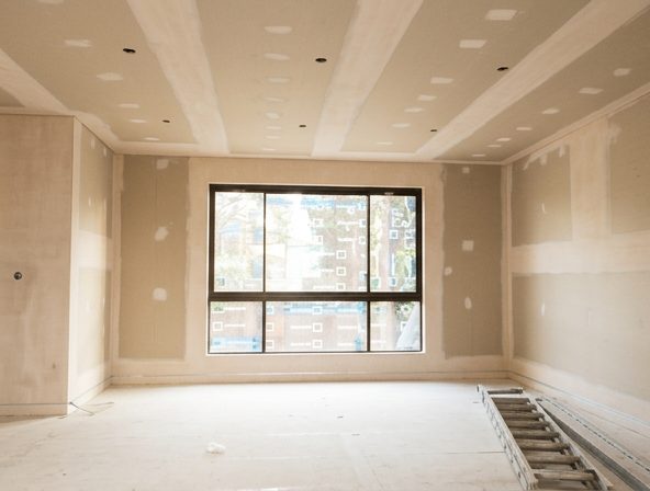 A room lined in acoustic board, sheeted and set on the walls and ceiling with the windows in.